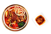 asian red noodle soup with vegetable, top flat view.