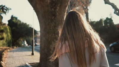 独自走在城市中心的年轻女子的背影.