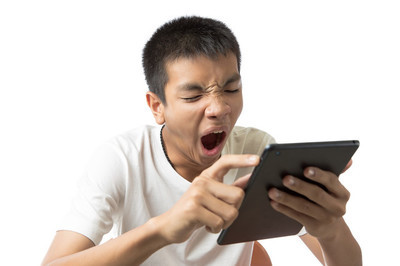 亚洲年轻人用他的平板电脑或 ipad 和打哈欠